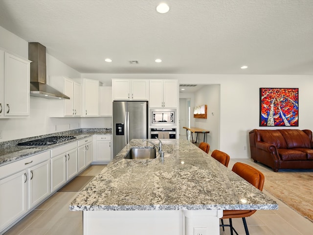 13 Firecrown Ln, Santa Fe, NM 87508 - kitchen featuring stainless steel appliances, wall chimney exhaust hood, a breakfast bar area, white cabinetry, and recessed lighting