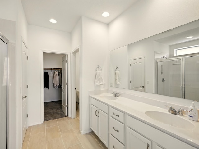 13 Firecrown Ln, Santa Fe, NM 87508 - bathroom featuring a shower stall, double vanity, a spacious closet, tile patterned floors, and recessed lighting