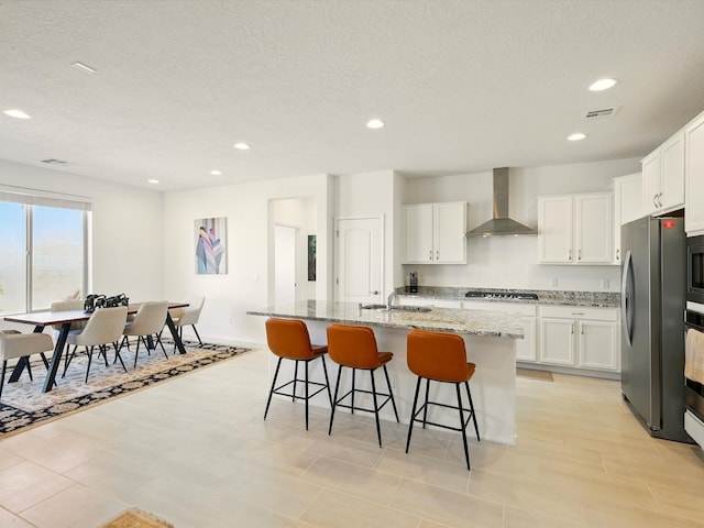 13 Firecrown Ln, Santa Fe, NM 87508 - kitchen featuring wall chimney exhaust hood, freestanding refrigerator, recessed lighting, a textured ceiling, and white cabinets