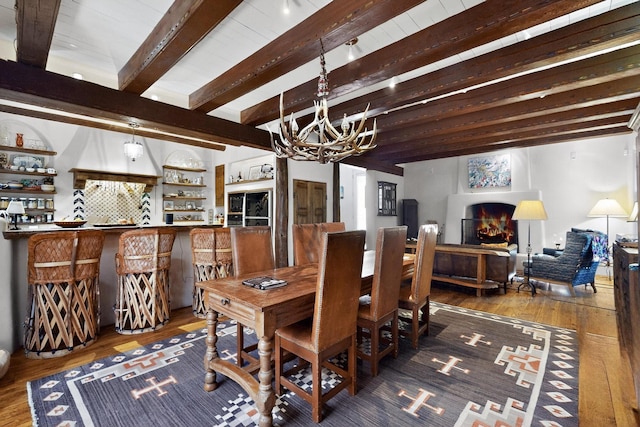 952 Acequia Madre, Santa Fe, NM 87505 - dining area featuring hardwood / wood-style floors, a chandelier, beam ceiling, and a lit fireplace