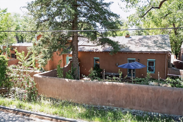 952 Acequia Madre, Santa Fe, NM 87505 - view of home's exterior with a metal roof and stucco siding