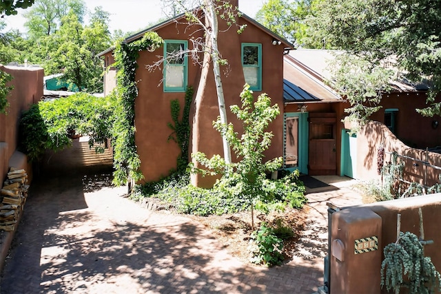 952 Acequia Madre, Santa Fe, NM 87505 - view of front facade featuring a standing seam roof, a metal roof, and stucco siding