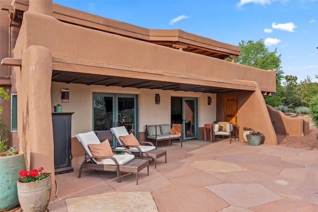 15 Cielo Cumbre Rd, Santa Fe, NM 87505 - rear view of house featuring stucco siding, a patio area, and an outdoor living space