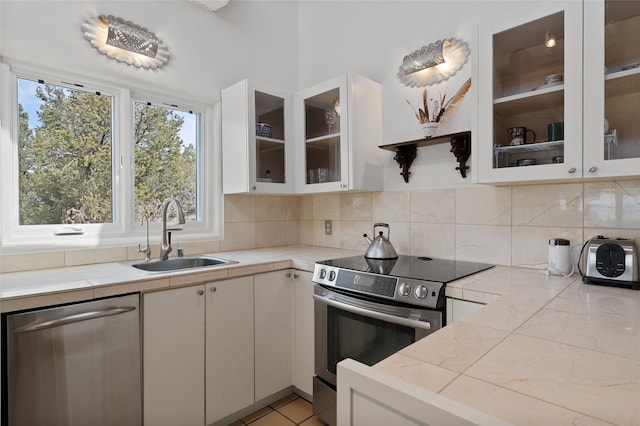 15 Cielo Cumbre Rd, Santa Fe, NM 87505 - kitchen featuring stainless steel appliances, decorative backsplash, white cabinets, and glass insert cabinets