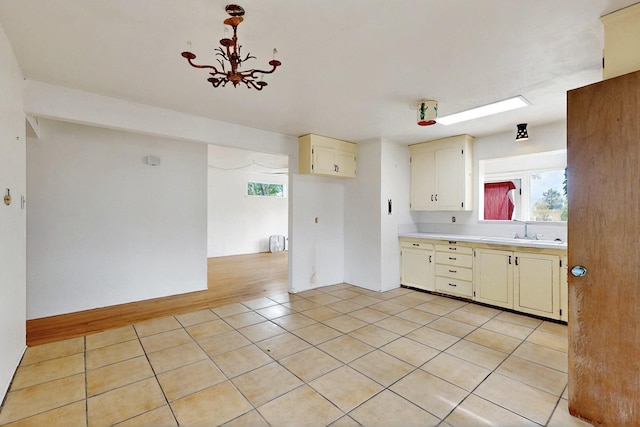 1017 Practilliano Dr, Santa Fe, NM 87505 - kitchen featuring light countertops, light tile patterned floors, a chandelier, and cream cabinets