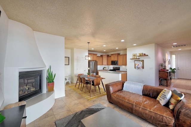 139 Rancho Viejo Blvd, Santa Fe, NM 87508 - living room featuring a textured ceiling, recessed lighting, a large fireplace, and light tile patterned floors