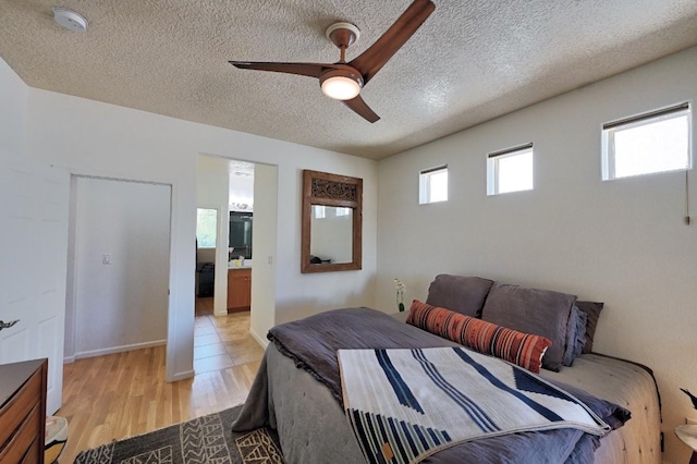 139 Rancho Viejo Blvd, Santa Fe, NM 87508 - bedroom featuring a textured ceiling, light wood-style floors, ceiling fan, and ensuite bath