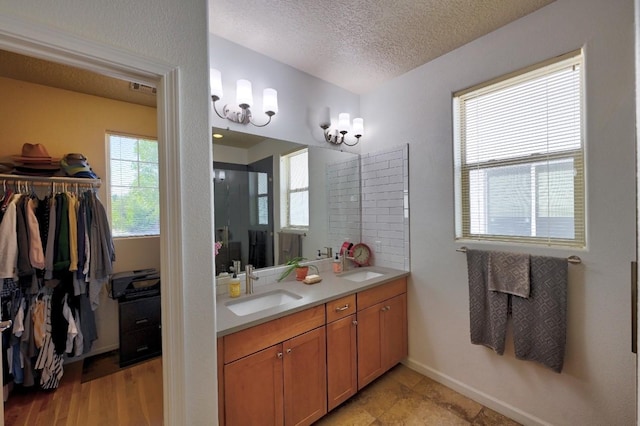 139 Rancho Viejo Blvd, Santa Fe, NM 87508 - bathroom featuring double vanity, a textured ceiling, and a walk in closet