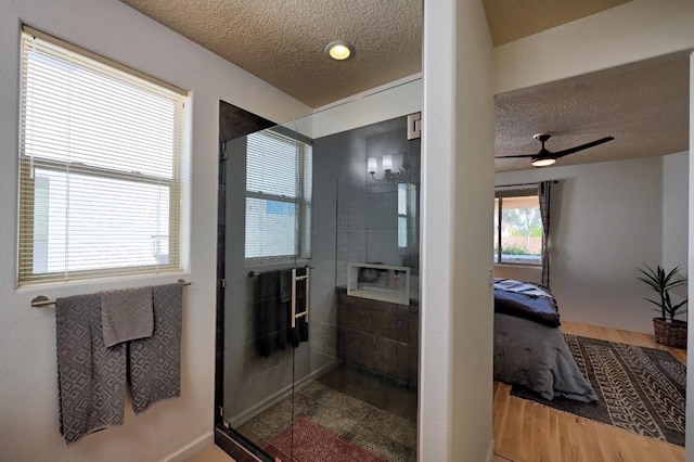 139 Rancho Viejo Blvd, Santa Fe, NM 87508 - full bath featuring a textured ceiling, connected bathroom, a stall shower, wood finished floors, and a ceiling fan