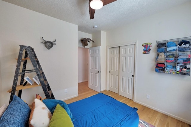 139 Rancho Viejo Blvd, Santa Fe, NM 87508 - bedroom featuring wood finished floors, a textured ceiling, a closet, and a ceiling fan