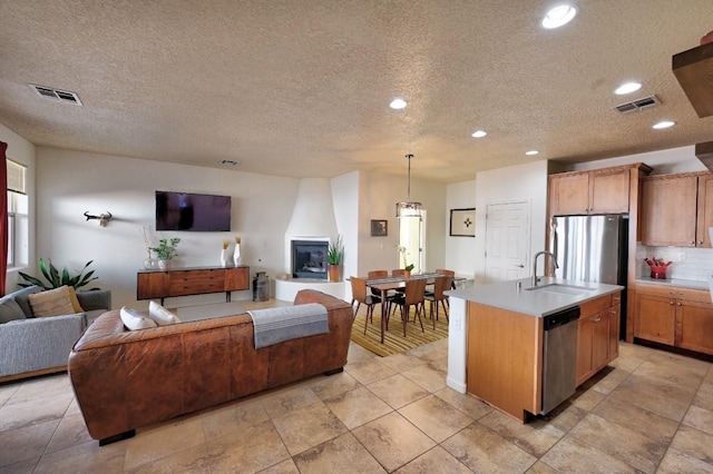 139 Rancho Viejo Blvd, Santa Fe, NM 87508 - kitchen featuring dishwasher, open floor plan, light countertops, a textured ceiling, and recessed lighting