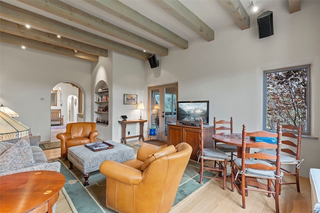 1203 Sierra Del Este, Santa Fe, NM 87501 - living room with arched walkways, beam ceiling, wood finished floors, a high ceiling, and built in features
