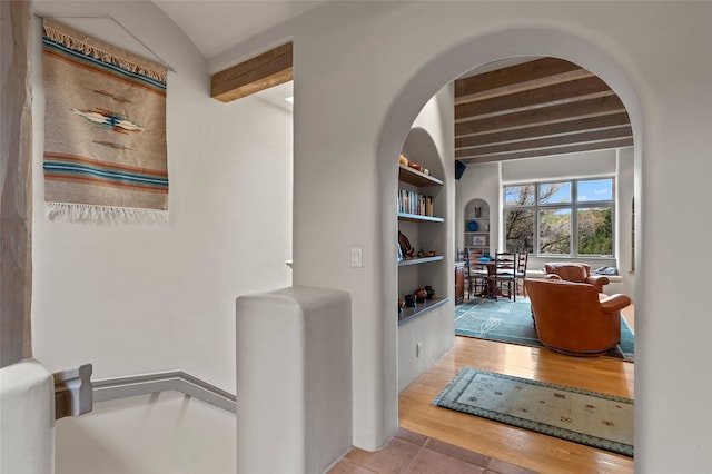1203 Sierra Del Este, Santa Fe, NM 87501 - hallway featuring beam ceiling, wood finished floors, arched walkways, and built in features