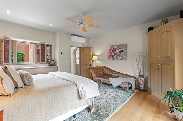 1203 Sierra Del Este, Santa Fe, NM 87501 - bedroom with a wall mounted air conditioner, light wood finished floors, arched walkways, ceiling fan, and recessed lighting