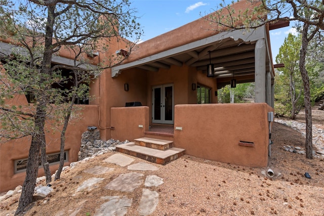 1203 Sierra Del Este, Santa Fe, NM 87501 - doorway to property with french doors and stucco siding