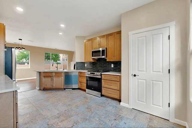 5 Wood Flower, Santa Fe, NM 87508 - kitchen featuring stainless steel appliances, a peninsula, light countertops, backsplash, and decorative light fixtures