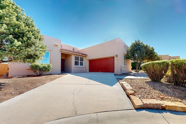 5 Wood Flower, Santa Fe, NM 87508 - pueblo-style house with driveway, stucco siding, and a garage