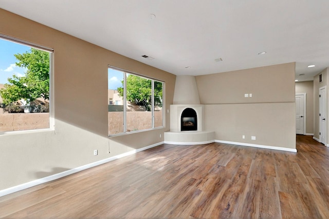5 Wood Flower, Santa Fe, NM 87508 - unfurnished living room with wood finished floors, plenty of natural light, a fireplace, and recessed lighting