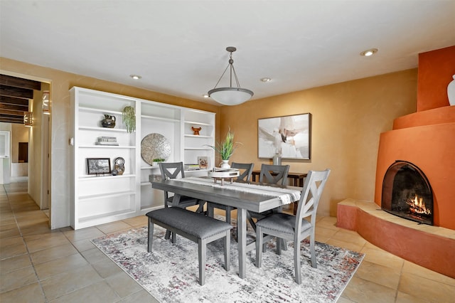 3046 Plaza Blanca, Santa Fe, NM 87507 - dining space featuring light tile patterned floors, recessed lighting, a large fireplace, and built in shelves