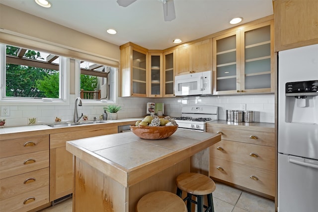 3046 Plaza Blanca, Santa Fe, NM 87507 - kitchen with white appliances, light brown cabinets, a breakfast bar, and recessed lighting