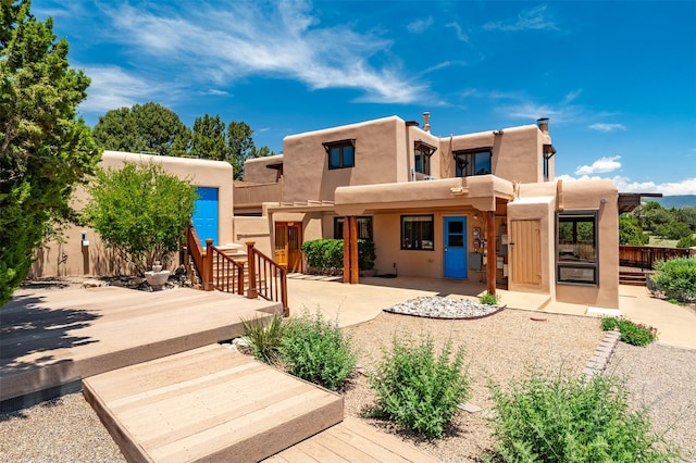 3046 Plaza Blanca, Santa Fe, NM 87507 - view of front of house with stucco siding, a patio area, and a deck