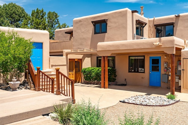 3046 Plaza Blanca, Santa Fe, NM 87507 - pueblo revival-style home with a balcony, stucco siding, and a patio
