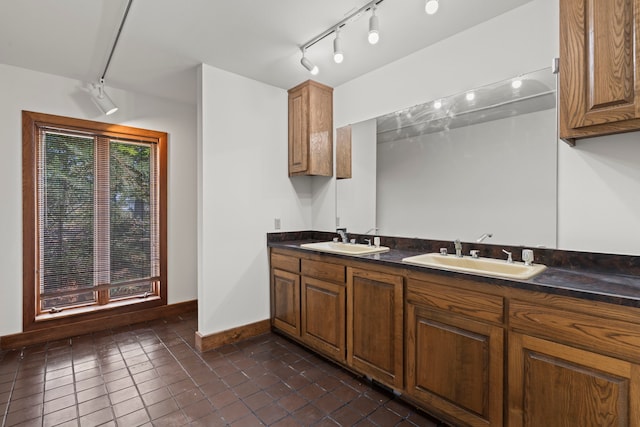 320 Valle Del Sol, White Rock, NM 87547 - kitchen featuring dark countertops, dark tile patterned flooring, brown cabinetry, and rail lighting