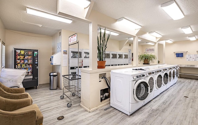 941 Calle Mejia Unit 413, Santa Fe, NM 87501 - shared laundry with estacked washer and dryer, independent washer and dryer, light wood-style floors, and a textured ceiling