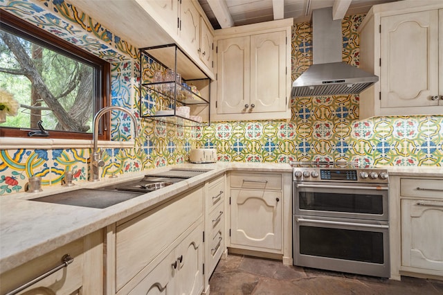 46 Sibley, Santa Fe, NM 87508 - kitchen featuring wall chimney exhaust hood, range with two ovens, beamed ceiling, tasteful backsplash, and dark stone finish floors