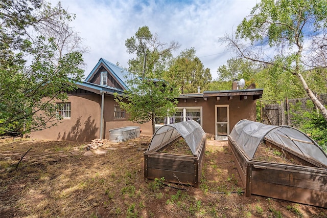46 Sibley, Santa Fe, NM 87508 - rear view of property featuring stucco siding and a garden