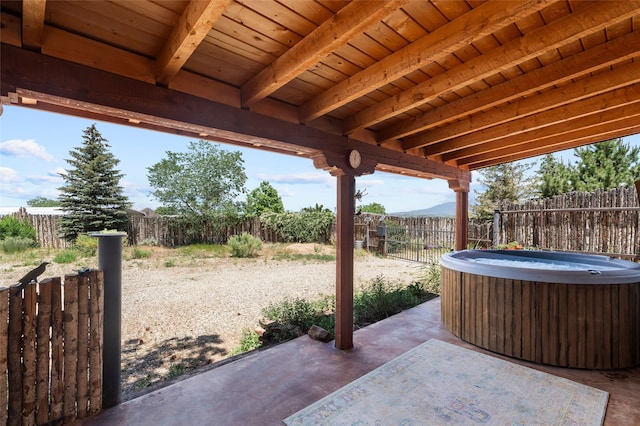 520 Este Es Rd, Taos, NM 87571 - fenced backyard featuring a hot tub, a patio area, and a mountain view