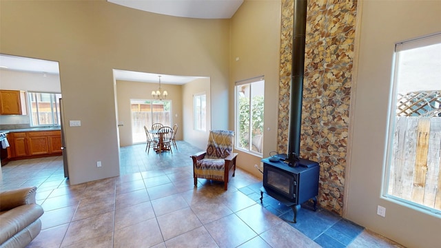 310 Grand Cyn, White Rock, NM 87547 - living area with plenty of natural light, a wood stove, a chandelier, a high ceiling, and light tile patterned floors