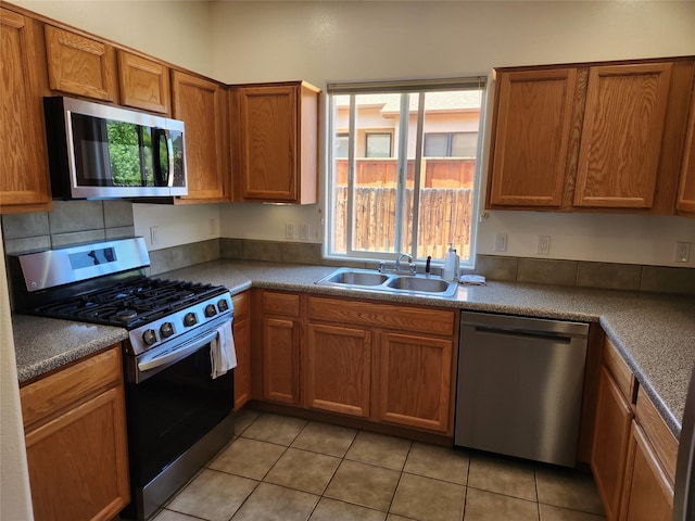 310 Grand Cyn, White Rock, NM 87547 - kitchen featuring stainless steel appliances, healthy amount of natural light, light tile patterned floors, and brown cabinets