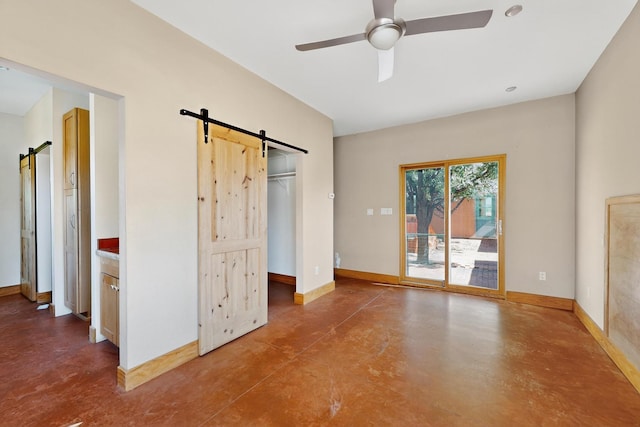 37 Camino Tetzcoco, Santa Fe, NM 87508 - unfurnished bedroom with a barn door, finished concrete flooring, and access to outside