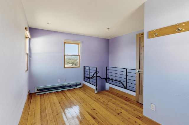 37 Camino Tetzcoco, Santa Fe, NM 87508 - unfurnished room featuring a baseboard radiator and light wood-style floors
