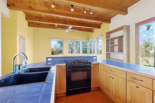 37 Camino Tetzcoco, Santa Fe, NM 87508 - kitchen featuring black range oven, track lighting, tile counters, a wood ceiling with exposed beams, and healthy amount of natural light