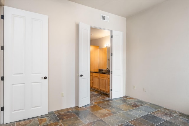 1405 Vegas Verdes Unit 136, Santa Fe, NM 87507 - unfurnished bedroom featuring stone tile flooring