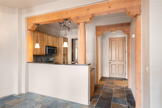 1405 Vegas Verdes Unit 136, Santa Fe, NM 87507 - kitchen featuring stone tile floors, stainless steel microwave, tasteful backsplash, stove, and pendant lighting