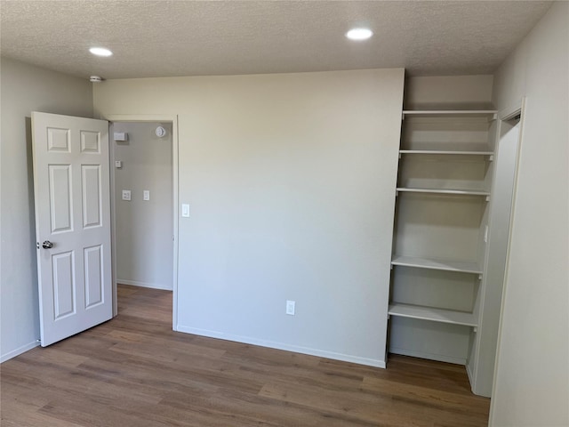 7512 Sagebrush, Santa Fe, NM 87507 - unfurnished bedroom featuring a textured ceiling, wood finished floors, recessed lighting, and a closet