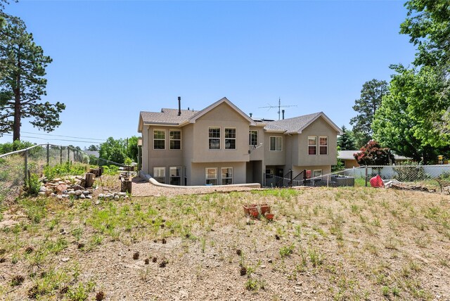 4857 Yucca St, Los Alamos, NM 87544 - back of house featuring stucco siding, a fenced backyard, and solar panels