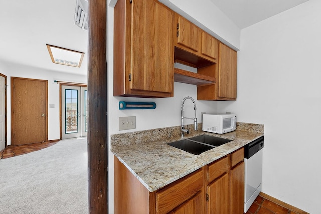 2600 Zia Unit C6, Santa Fe, NM 87505 - kitchen featuring white appliances, light stone counters, and brown cabinets