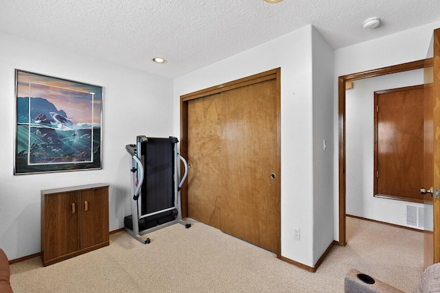 7507 Kachina Loop, Santa Fe, NM 87507 - workout area featuring light colored carpet and a textured ceiling
