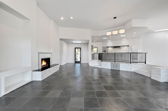 117 La Ventana, Santa Fe, NM 87508 - unfurnished living room with a lit fireplace and recessed lighting