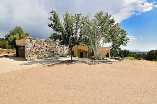 117 La Ventana, Santa Fe, NM 87508 - pueblo-style home with stucco siding, a garage, and driveway