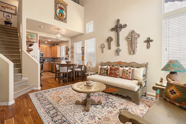 4351 San Benito Unit A, Santa Fe, NM 87507 - living area with stairway, plenty of natural light, wood finished floors, and a towering ceiling