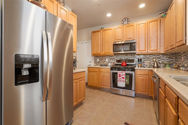 4351 San Benito Unit A, Santa Fe, NM 87507 - kitchen featuring appliances with stainless steel finishes, backsplash, light countertops, light tile patterned floors, and recessed lighting