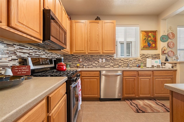 4351 San Benito Unit A, Santa Fe, NM 87507 - kitchen with appliances with stainless steel finishes, light countertops, backsplash, and light tile patterned floors