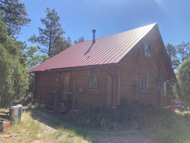 32 Doe Rim Loop, Los Ojos, NM 87551 - view of side of home with log exterior, a standing seam roof, and a metal roof