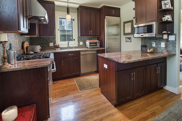 111 E Santa Fe Unit 5, Santa Fe, NM 87505 - kitchen with appliances with stainless steel finishes, light wood-style floors, tasteful backsplash, and exhaust hood
