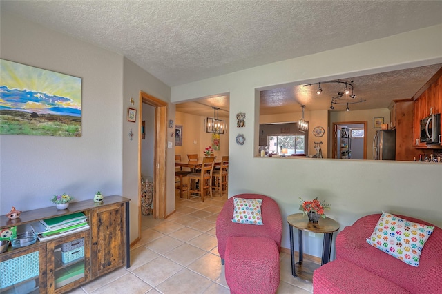 7513 Kachina Loop, Santa Fe, NM 87507 - living area featuring a textured ceiling, a chandelier, light tile patterned floors, and rail lighting